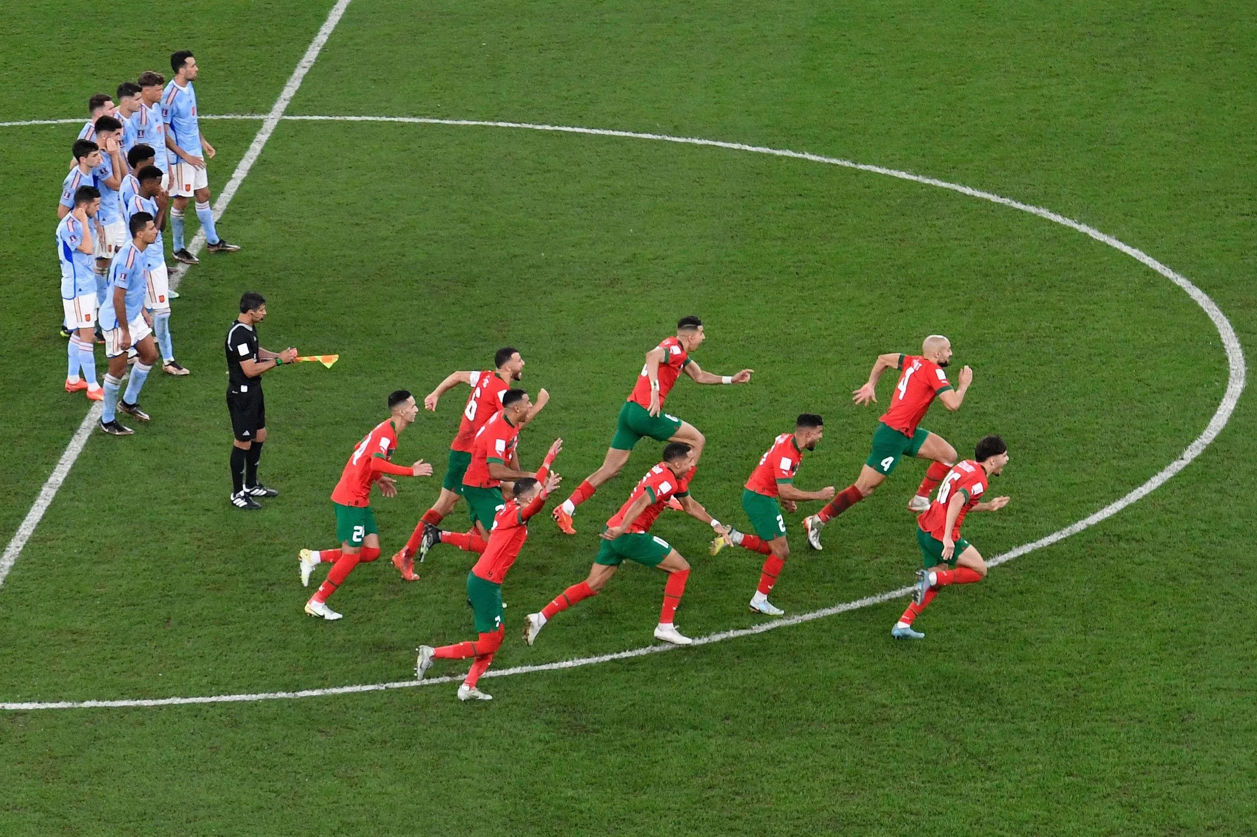 Morocco’s players go on the charge after their penalty shootout victory over Spain at the 2022 World Cup